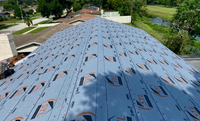 Synthetic underlayment installed across a large roof, aerial view